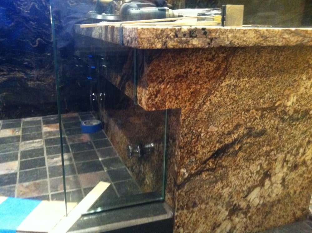 Frameless shower glass notched around a granite bench during installation